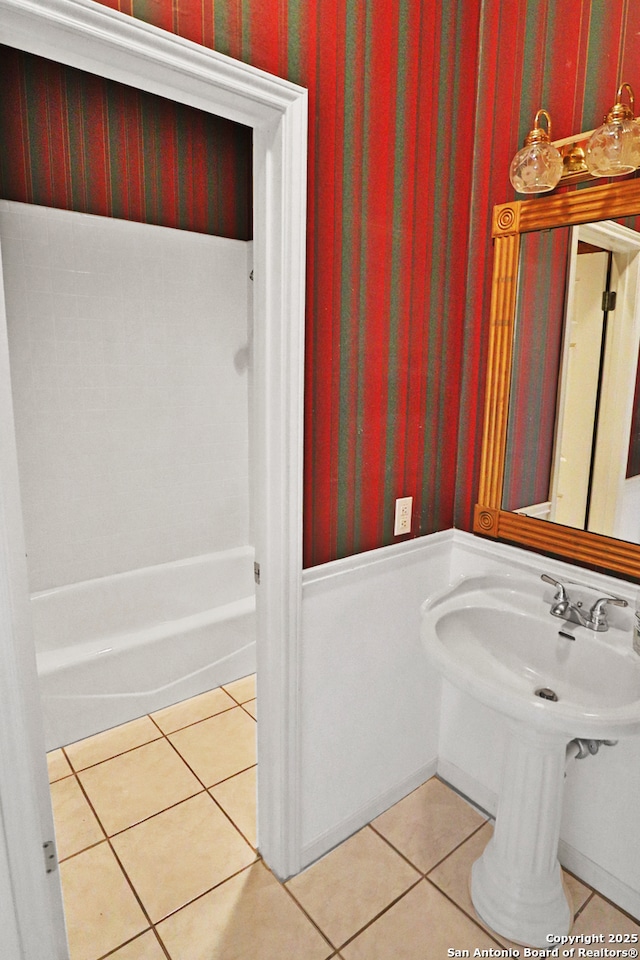 bathroom with wallpapered walls, tile patterned flooring, and a bathtub