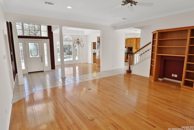 foyer featuring visible vents, light wood-style floors, stairs, ornamental molding, and decorative columns