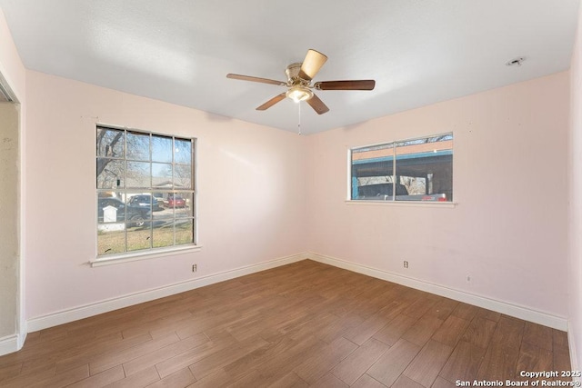 unfurnished room featuring wood finished floors, a ceiling fan, and baseboards