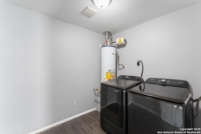 laundry area featuring gas water heater, laundry area, separate washer and dryer, dark wood-style flooring, and visible vents