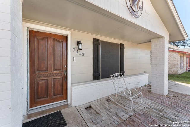 entrance to property featuring brick siding