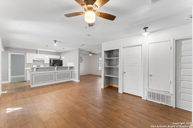 unfurnished living room with a ceiling fan, baseboards, visible vents, and wood finished floors