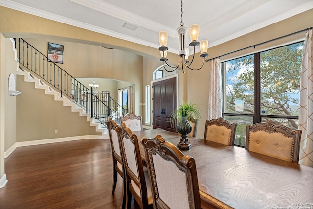 dining space featuring arched walkways, a notable chandelier, dark wood-style flooring, stairs, and a tray ceiling