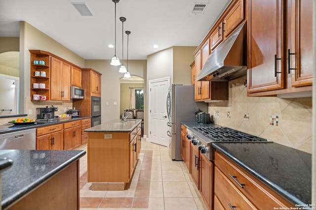 kitchen with pendant lighting, a center island with sink, open shelves, stainless steel appliances, and under cabinet range hood