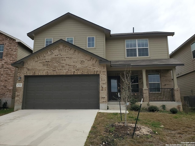 view of front of house featuring a porch, concrete driveway, and brick siding