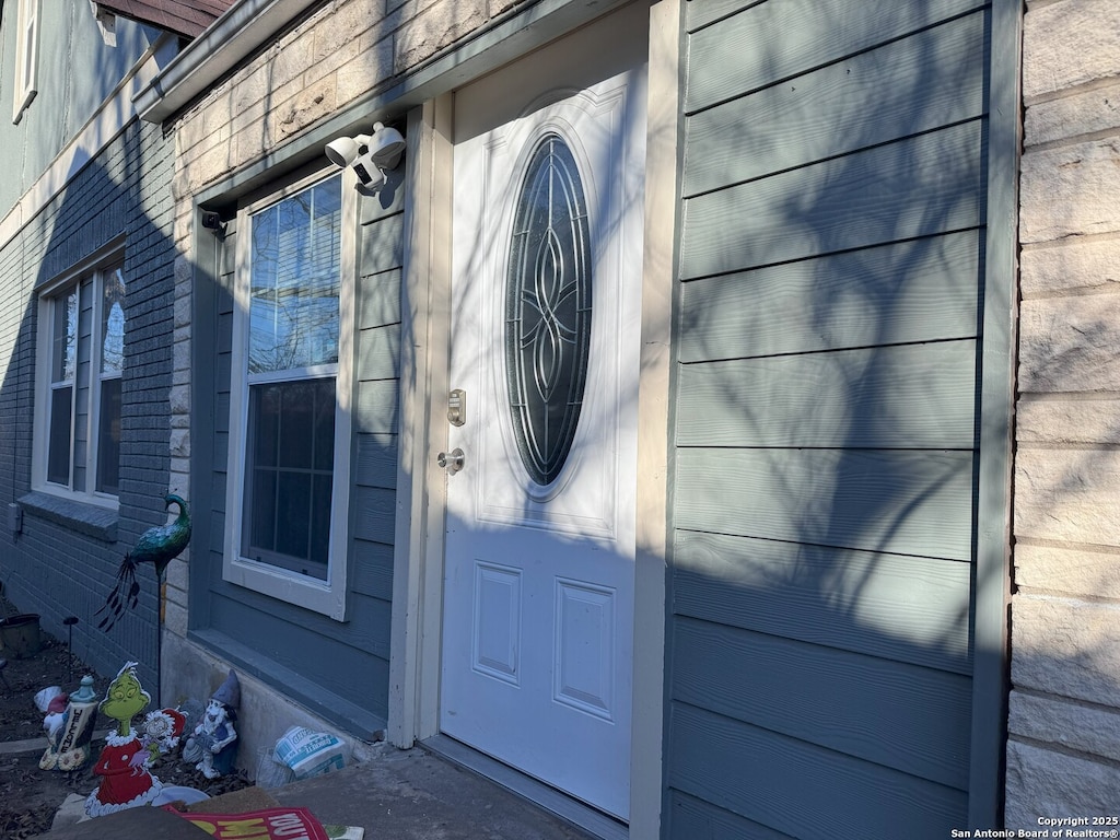 entrance to property featuring brick siding