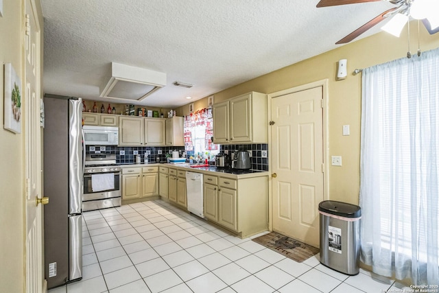 kitchen featuring stainless steel appliances, dark countertops, light tile patterned flooring, and decorative backsplash