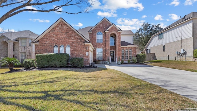 traditional-style home featuring brick siding and a front yard