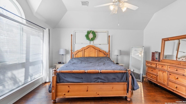 bedroom featuring dark wood-style floors, lofted ceiling, visible vents, and a ceiling fan