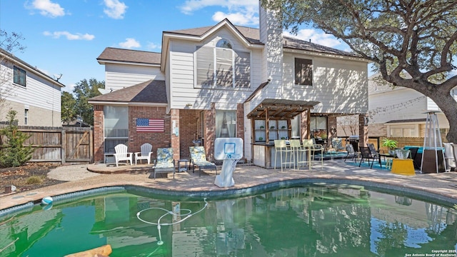 rear view of property featuring a shingled roof, fence, a patio area, a pergola, and brick siding