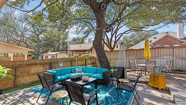 wooden deck featuring outdoor dining area, a fenced backyard, and an outdoor hangout area