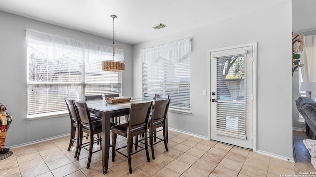 dining room featuring baseboards, visible vents, a wealth of natural light, and light tile patterned flooring