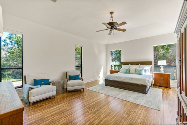 bedroom with multiple windows, light wood-type flooring, and a ceiling fan