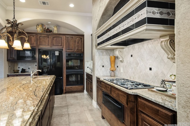 kitchen with a warming drawer, black appliances, visible vents, and light stone countertops