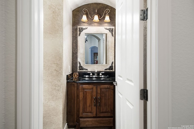 bathroom featuring a textured wall and vanity