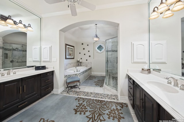 bathroom featuring a bath, crown molding, two vanities, and a sink