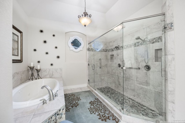 bathroom featuring a jetted tub, a stall shower, baseboards, and tile patterned floors