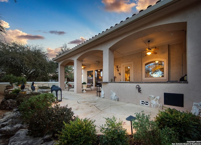 patio terrace at dusk featuring a ceiling fan