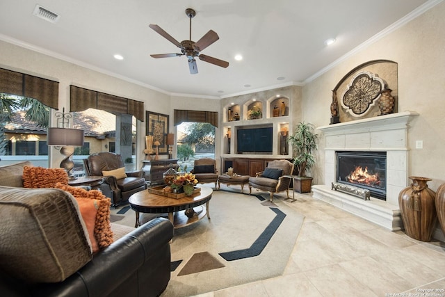 living room featuring recessed lighting, visible vents, ornamental molding, a glass covered fireplace, and ceiling fan