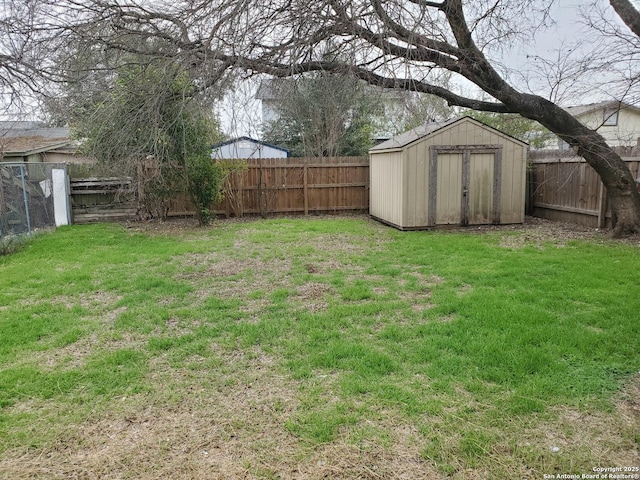 view of yard with an outbuilding, a fenced backyard, and a storage unit