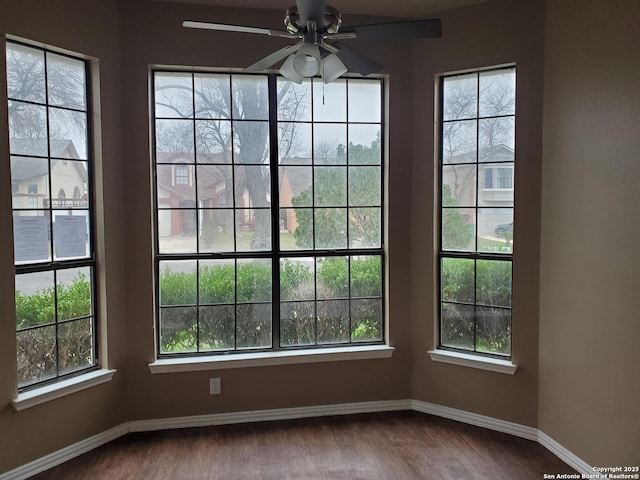 empty room featuring ceiling fan, wood finished floors, and baseboards