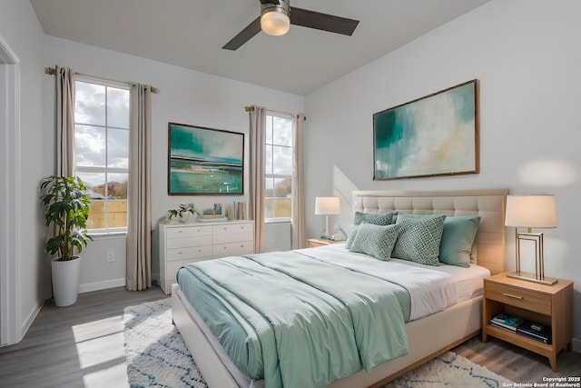 bedroom with a ceiling fan, baseboards, and wood finished floors