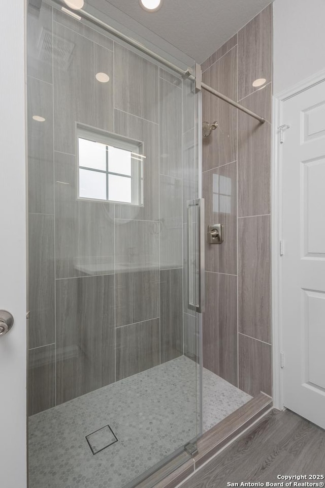 full bath with a stall shower and wood finished floors