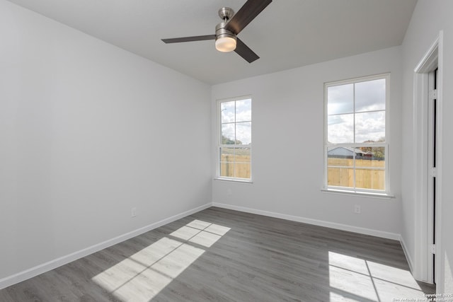 empty room featuring ceiling fan, light wood-style flooring, and baseboards