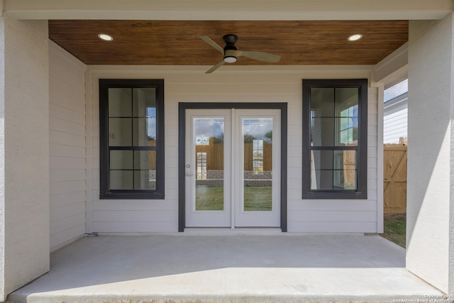 doorway to property featuring ceiling fan, fence, and a patio