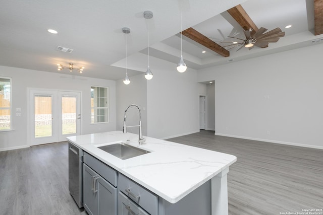 kitchen with open floor plan, a center island with sink, a sink, and decorative light fixtures