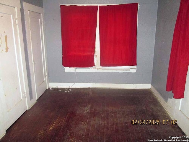 empty room with baseboards and hardwood / wood-style floors