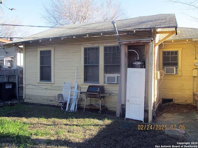 back of house with roof with shingles