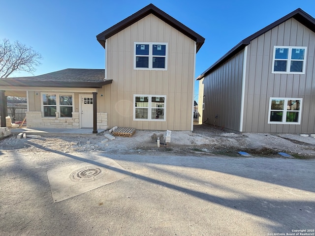 view of front of property with stone siding and a shingled roof