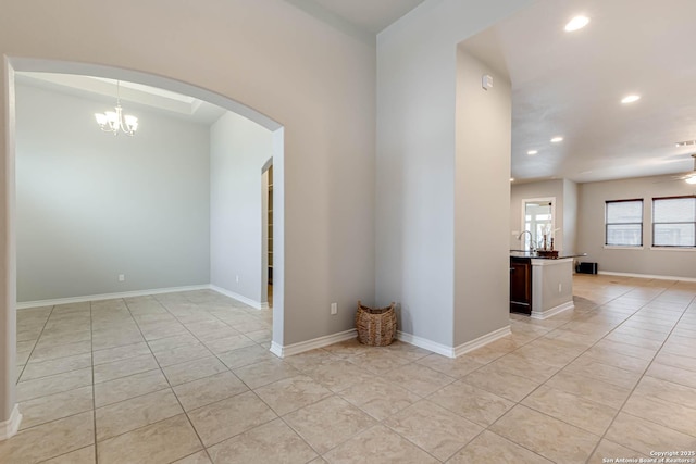 unfurnished room featuring recessed lighting, baseboards, arched walkways, and light tile patterned flooring