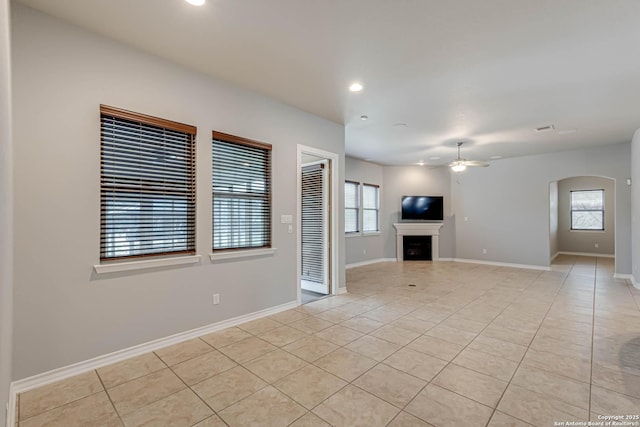 unfurnished living room featuring light tile patterned floors, recessed lighting, a fireplace, and baseboards