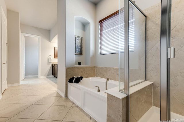 bathroom featuring a garden tub, a stall shower, vanity, tile patterned flooring, and baseboards