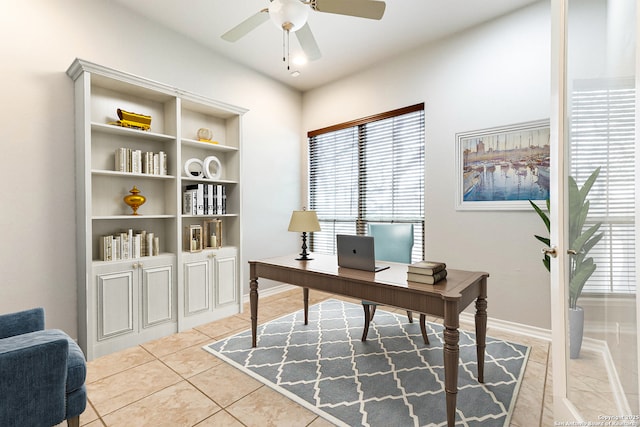 office space with ceiling fan, baseboards, and light tile patterned floors