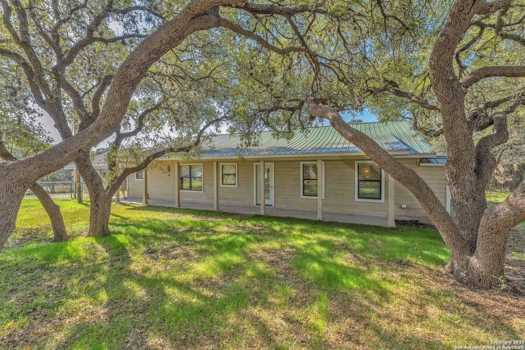 337 Mills Ln, Pipe Creek, TX 78063 - single story home with metal roof and a front yard