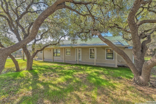 single story home with metal roof and a front yard