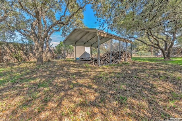 view of yard featuring fence and a detached carport