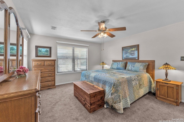 bedroom with light carpet, baseboards, visible vents, ceiling fan, and a textured ceiling