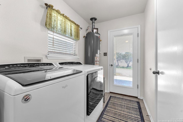 laundry room featuring laundry area, baseboards, washer and dryer, gas water heater, and light tile patterned flooring