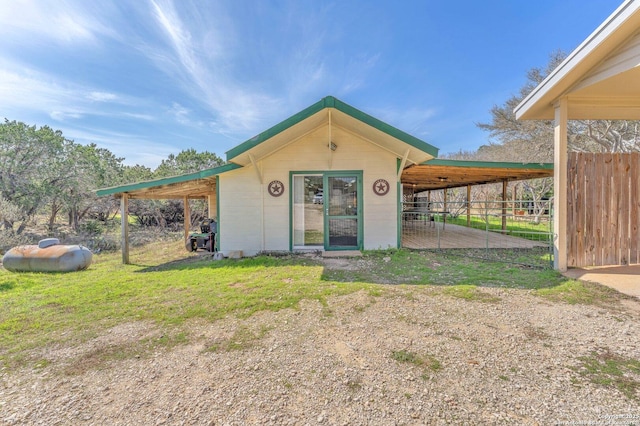 view of outdoor structure featuring an attached carport and driveway