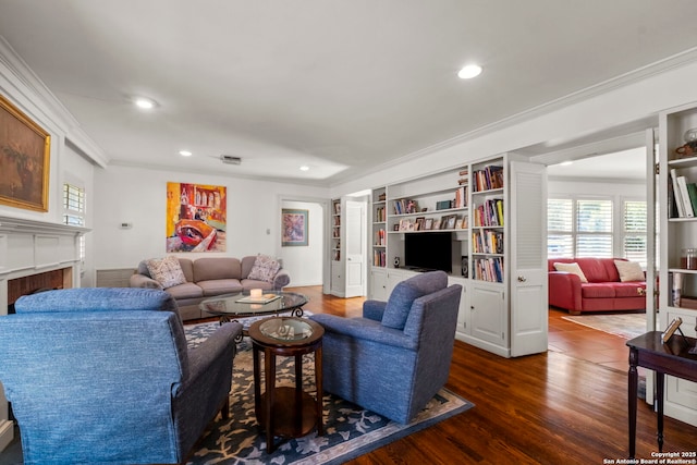 living area with built in features, a fireplace, dark wood finished floors, recessed lighting, and ornamental molding