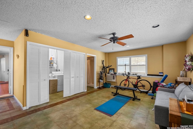 exercise room featuring ceiling fan, baseboards, a textured ceiling, and tile patterned floors