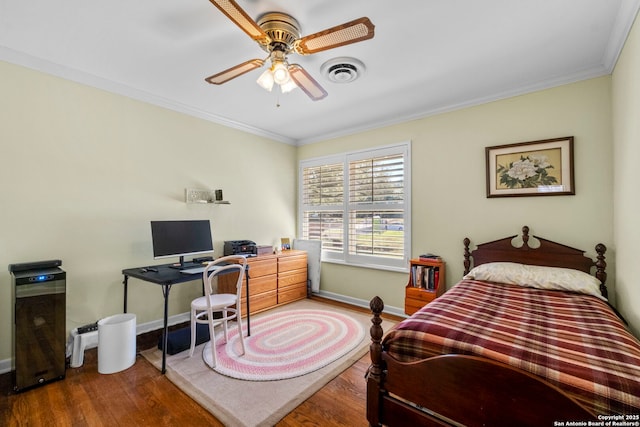 bedroom with visible vents, crown molding, baseboards, and wood finished floors