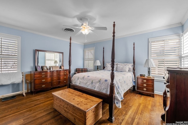 bedroom featuring baseboards, visible vents, crown molding, and wood finished floors