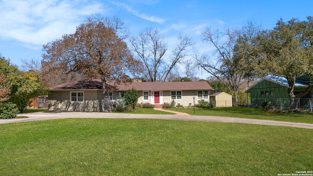 ranch-style home featuring driveway, a front lawn, and fence