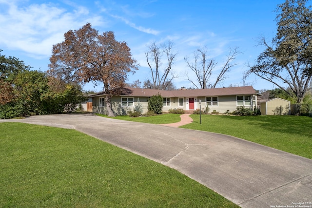 ranch-style house featuring a front yard, driveway, and an outdoor structure