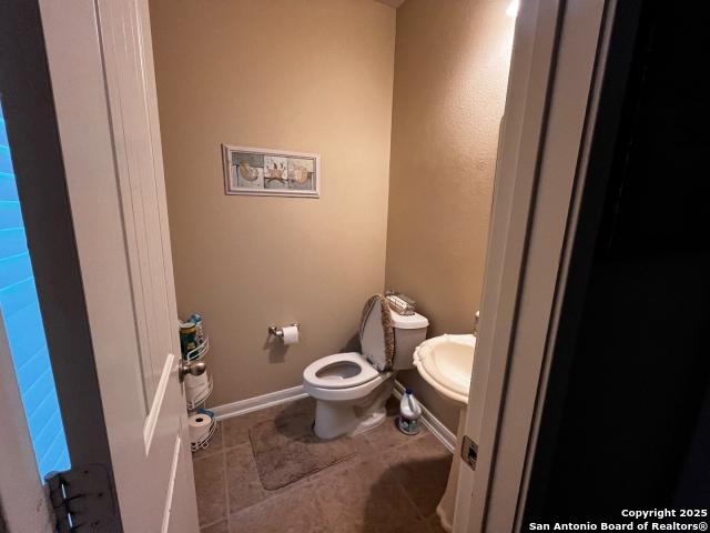 bathroom featuring tile patterned flooring, baseboards, and toilet